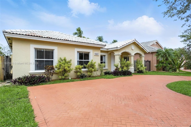 8899 NW 169th Ter, Hialeah, FL 33018 - view of front facade featuring curved driveway, stucco siding, and a tiled roof
