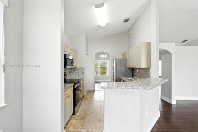 8899 NW 169th Ter, Hialeah, FL 33018 - kitchen with appliances with stainless steel finishes, tasteful backsplash, arched walkways, a peninsula, and light countertops