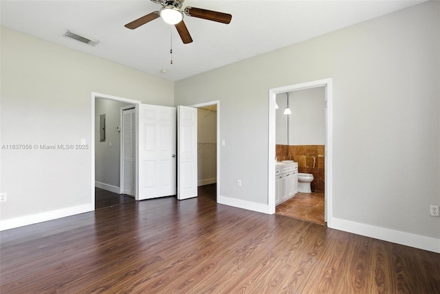 8899 NW 169th Ter, Hialeah, FL 33018 - unfurnished bedroom featuring electric panel, wood finished floors, connected bathroom, a spacious closet, and ceiling fan