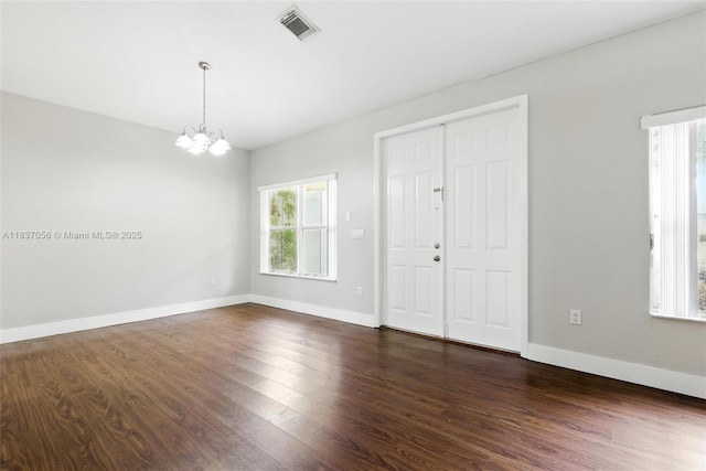 8899 NW 169th Ter, Hialeah, FL 33018 - empty room with healthy amount of natural light, a chandelier, and dark wood-style floors