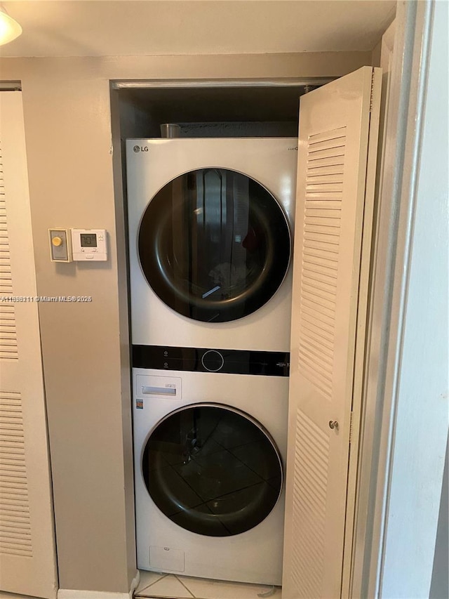 2205 S Cypress Bend Dr Unit 302, Pompano Beach, FL 33069 - laundry room featuring stacked washer / drying machine and tile patterned flooring