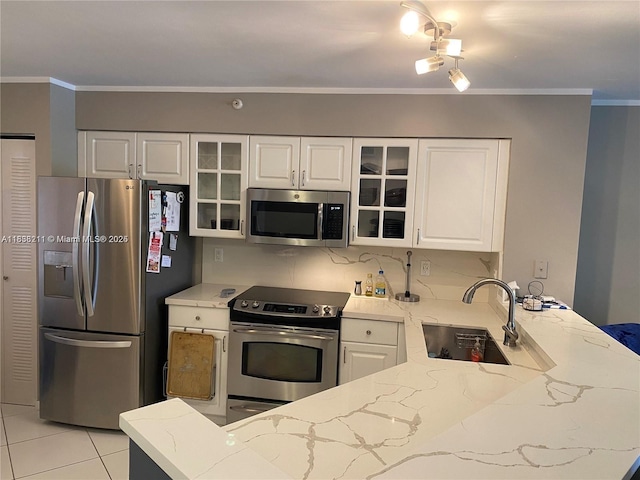 2205 S Cypress Bend Dr Unit 302, Pompano Beach, FL 33069 - kitchen featuring appliances with stainless steel finishes, a peninsula, light stone countertops, glass insert cabinets, and crown molding