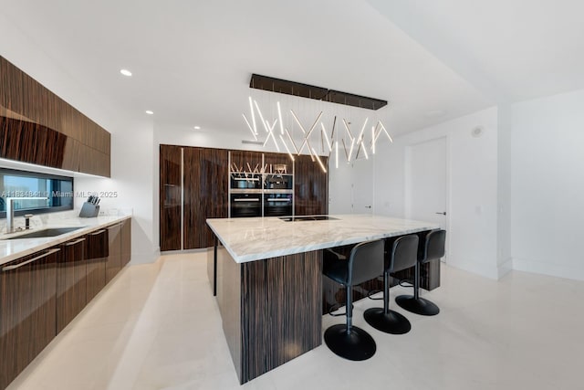 18555 Collins Ave Unit 2003, Sunny Isles Beach, FL 33160 - kitchen with modern cabinets, a breakfast bar area, light stone countertops, recessed lighting, and a large island