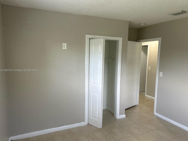 4021 NW 7th Ave, Deerfield Beach, FL 33064 - unfurnished bedroom featuring a closet, light tile patterned floors, and a textured ceiling