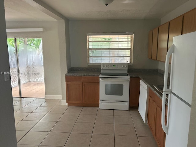 5456 NW 1st Ave, Oakland Park, FL 33309 - kitchen featuring white appliances, dark countertops, and light tile patterned floors