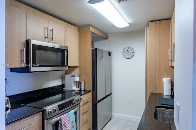 10275 Collins Ave Unit 634, Bal Harbour, FL 33154 - kitchen with stainless steel appliances, light brown cabinets, and dark stone countertops