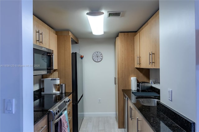 10275 Collins Ave Unit 634, Bal Harbour, FL 33154 - kitchen featuring stainless steel appliances, light brown cabinets, and dark stone counters