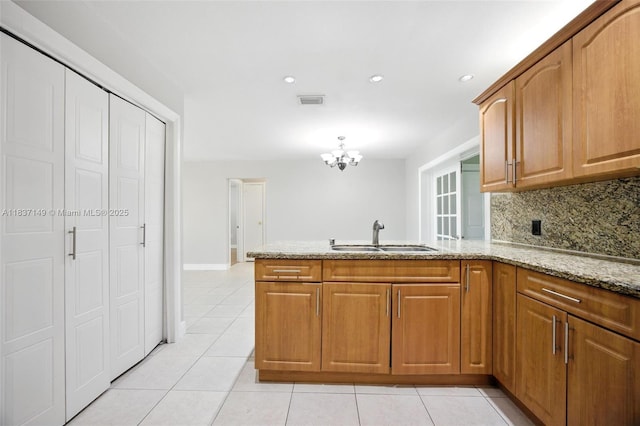 9540 NW 25th St, Sunrise, FL 33322 - kitchen with a peninsula, light stone counters, light tile patterned floors, decorative backsplash, and recessed lighting