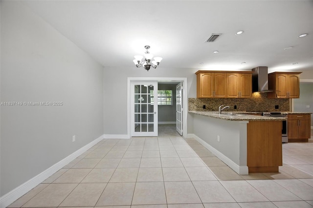 9540 NW 25th St, Sunrise, FL 33322 - kitchen featuring a chandelier, decorative backsplash, a peninsula, light stone countertops, and brown cabinets