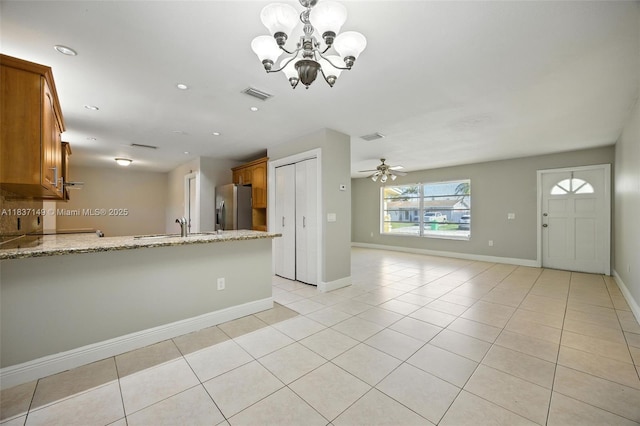 9540 NW 25th St, Sunrise, FL 33322 - kitchen featuring brown cabinets, a peninsula, a chandelier, open floor plan, and recessed lighting