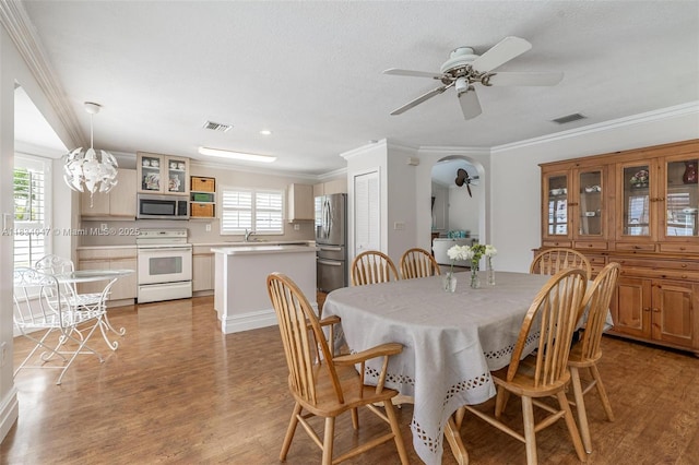4125 SW 152nd Ave, Miramar, FL 33027 - dining area with ceiling fan, crown molding, light wood finished floors, arched walkways, and a chandelier