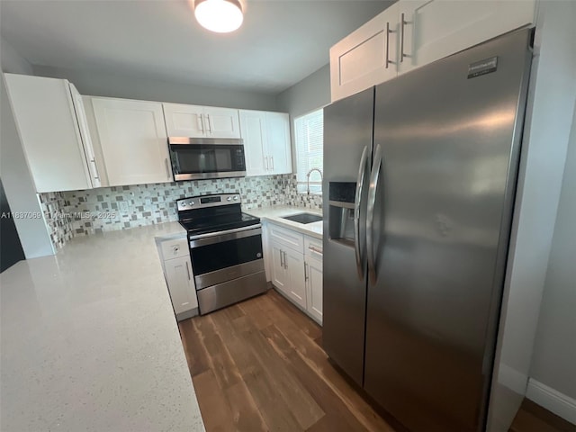2569 NW 61st Ave, Margate, FL 33063 - kitchen with appliances with stainless steel finishes, light countertops, white cabinets, tasteful backsplash, and dark wood-type flooring