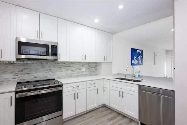 1200 SW 12th St Unit 214, Fort Lauderdale, FL 33315 - kitchen featuring appliances with stainless steel finishes, light countertops, white cabinets, backsplash, and recessed lighting