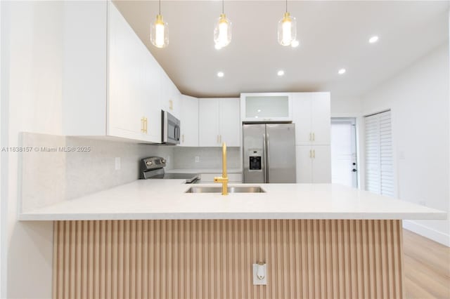 1896 NW 66th St, Miami, FL 33147 - kitchen with appliances with stainless steel finishes, a peninsula, light countertops, light wood finished floors, and a breakfast bar area