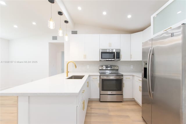1896 NW 66th St, Miami, FL 33147 - kitchen with appliances with stainless steel finishes, a peninsula, light wood-type flooring, vaulted ceiling, and white cabinets