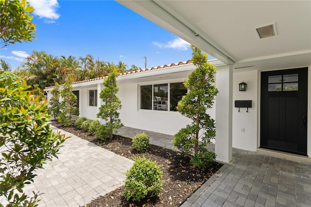 1710 SW 1st Ave, Pompano Beach, FL 33060 - doorway to property featuring stucco siding and a tiled roof