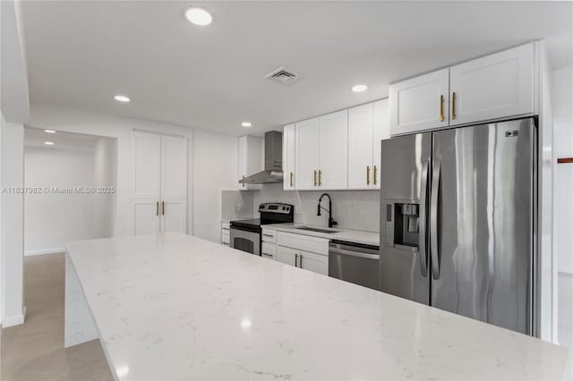 1710 SW 1st Ave, Pompano Beach, FL 33060 - kitchen with appliances with stainless steel finishes, wall chimney range hood, recessed lighting, white cabinetry, and tasteful backsplash