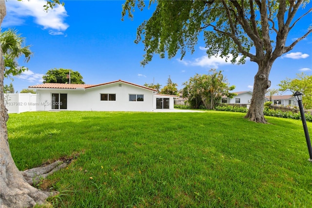 1710 SW 1st Ave, Pompano Beach, FL 33060 - back of house with stucco siding, a yard, and a metal roof