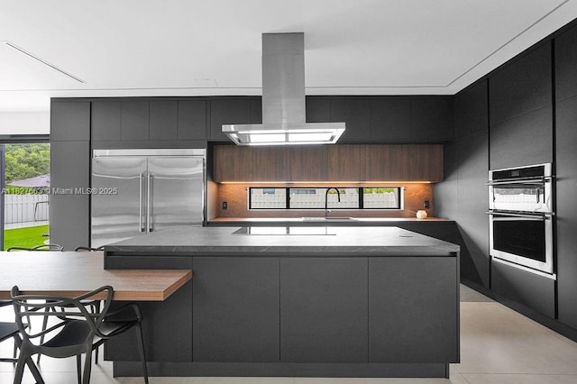 10746 Charleston Pl, Cooper City, FL 33026 - kitchen featuring stainless steel appliances, island exhaust hood, modern cabinets, dark cabinetry, and a center island