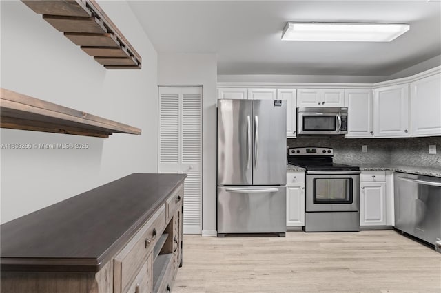 10104 Royal Palm Blvd Unit 107-C, Coral Springs, FL 33065 - kitchen featuring appliances with stainless steel finishes, white cabinetry, light wood-style flooring, and decorative backsplash