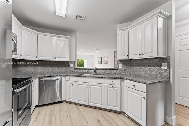 10104 Royal Palm Blvd Unit 107-C, Coral Springs, FL 33065 - kitchen featuring appliances with stainless steel finishes, light wood finished floors, white cabinets, tasteful backsplash, and recessed lighting