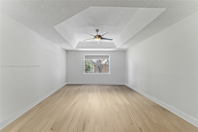 10104 Royal Palm Blvd Unit 107-C, Coral Springs, FL 33065 - empty room featuring a textured ceiling, light wood-type flooring, a ceiling fan, and a raised ceiling