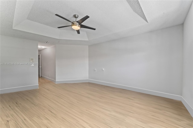 10104 Royal Palm Blvd Unit 107-C, Coral Springs, FL 33065 - spare room featuring a textured ceiling, ceiling fan, light wood-type flooring, and a raised ceiling