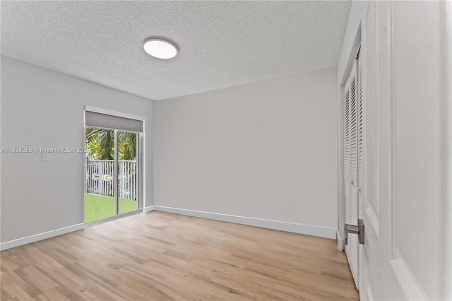 10104 Royal Palm Blvd Unit 107-C, Coral Springs, FL 33065 - unfurnished bedroom with light wood-style flooring, a textured ceiling, access to outside, and a closet