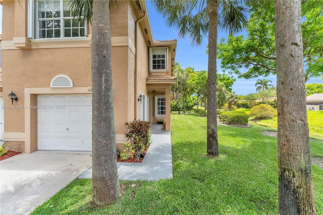 10104 Royal Palm Blvd Unit 107-C, Coral Springs, FL 33065 - view of front of home with stucco siding, a garage, a front lawn, and concrete driveway
