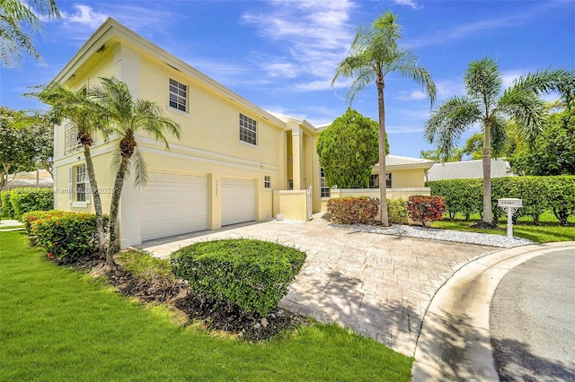 15281 Wilshire Ct, Pembroke Pines, FL 33027 - view of front facade featuring an attached garage, stucco siding, driveway, and a front lawn