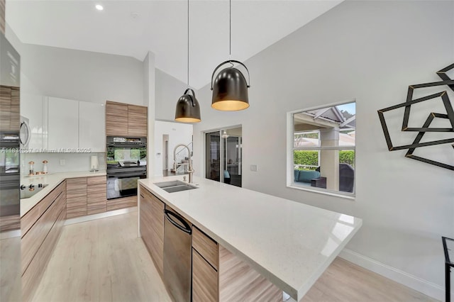 15281 Wilshire Ct, Pembroke Pines, FL 33027 - kitchen with modern cabinets, black appliances, high vaulted ceiling, light countertops, and light wood-type flooring