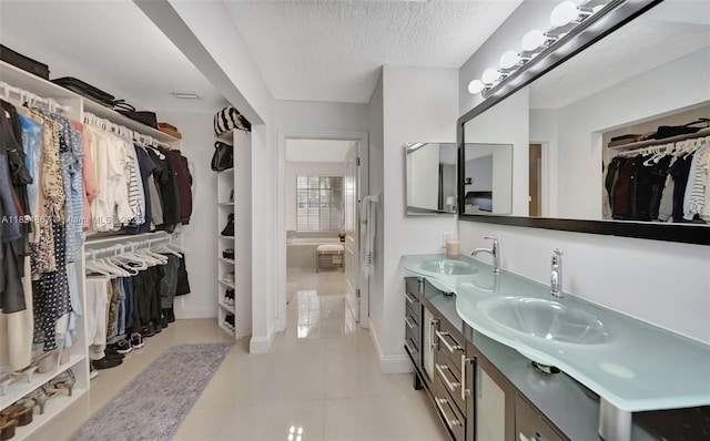 15281 Wilshire Ct, Pembroke Pines, FL 33027 - full bathroom featuring a walk in closet, double vanity, a textured ceiling, and tile patterned flooring