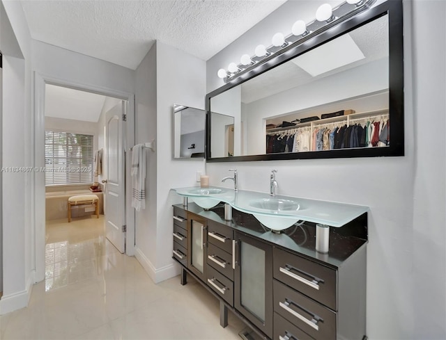 15281 Wilshire Ct, Pembroke Pines, FL 33027 - bathroom with double vanity, a spacious closet, and a textured ceiling