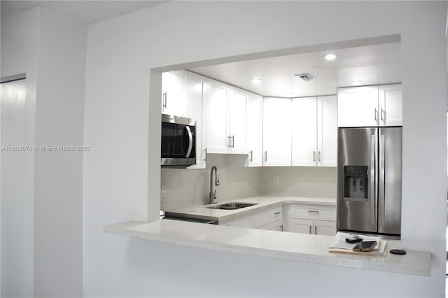 1075 W 68th St Unit 110, Hialeah, FL 33014 - kitchen with stainless steel appliances, white cabinetry, light stone counters, and recessed lighting