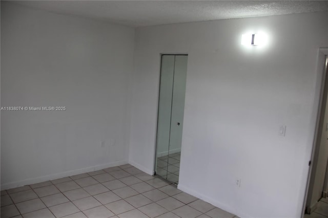 1075 W 68th St Unit 110, Hialeah, FL 33014 - unfurnished room with light tile patterned flooring and a textured ceiling