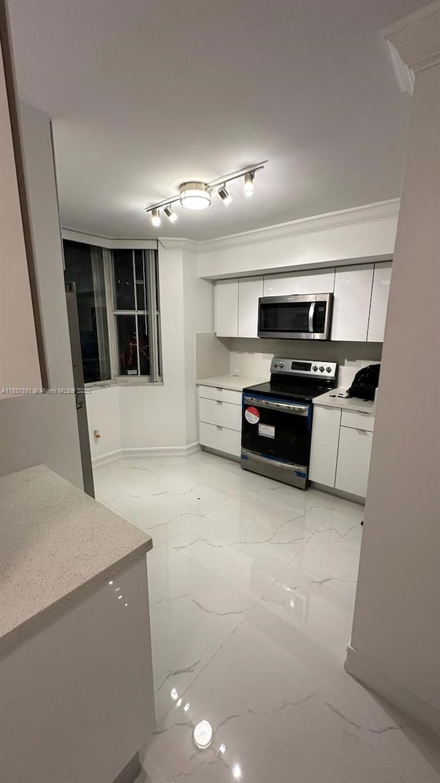 8680 NW 3rd Ln Unit 303, Miami, FL 33126 - kitchen with appliances with stainless steel finishes, white cabinets, light marble finish flooring, and ornamental molding