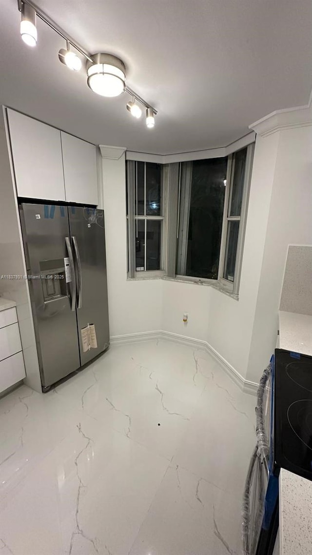 8680 NW 3rd Ln Unit 303, Miami, FL 33126 - kitchen with stainless steel fridge with ice dispenser, light marble finish flooring, white cabinetry, and range with electric stovetop
