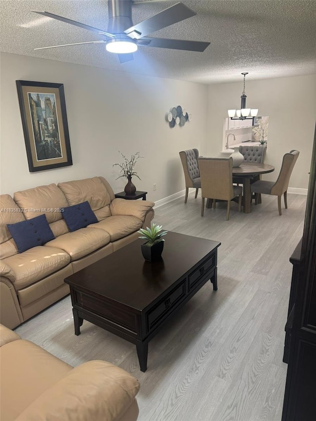 7480 NW 17th St Unit 103, Plantation, FL 33313 - living room featuring a chandelier, light wood-style flooring, ceiling fan, and a textured ceiling