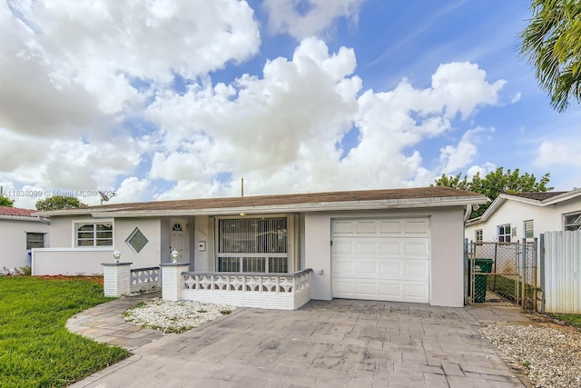 7904 Alhambra Blvd, Miramar, FL 33023 - ranch-style house with an attached garage, stucco siding, covered porch, a gate, and driveway