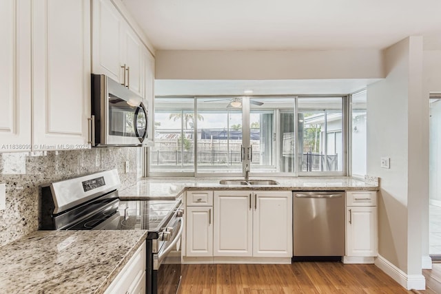 7904 Alhambra Blvd, Miramar, FL 33023 - kitchen with stainless steel appliances, decorative backsplash, white cabinets, and light wood finished floors