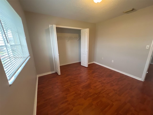 6865 SW 158th Pl, Miami, FL 33193 - unfurnished bedroom featuring multiple windows, dark wood finished floors, a closet, and a textured ceiling