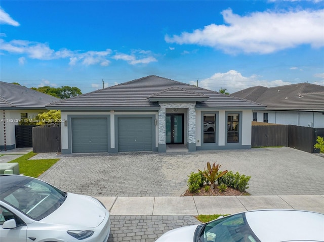 14832 SW 39th Ter, Miami, FL 33185 - view of front of property with an attached garage, a tile roof, stucco siding, decorative driveway, and french doors