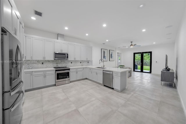 14832 SW 39th Ter, Miami, FL 33185 - kitchen featuring appliances with stainless steel finishes, tasteful backsplash, a peninsula, light countertops, and open floor plan