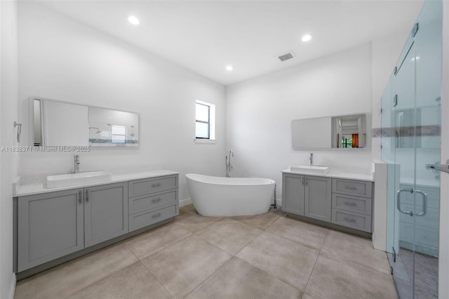 14832 SW 39th Ter, Miami, FL 33185 - bathroom featuring two vanities, a shower stall, a freestanding bath, recessed lighting, and tile patterned floors