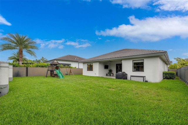 14832 SW 39th Ter, Miami, FL 33185 - back of house with a playground, stucco siding, a fenced backyard, a tiled roof, and a patio