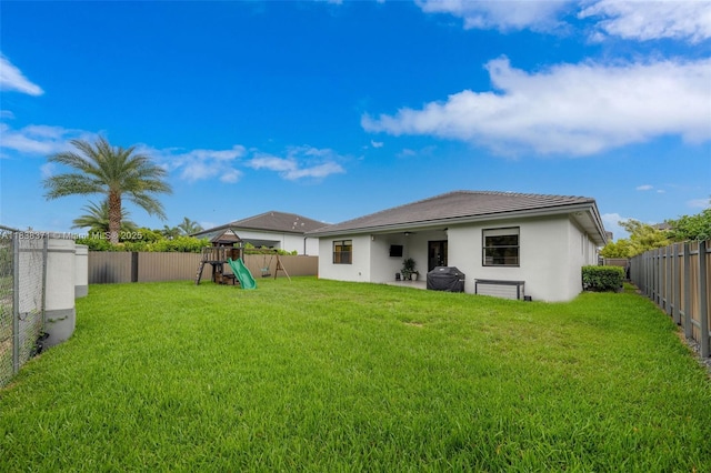 14832 SW 39th Ter, Miami, FL 33185 - rear view of property featuring a playground, a fenced backyard, stucco siding, and a tile roof