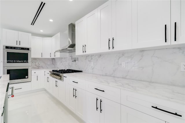 9800 SW 159th St, Miami, FL 33157 - kitchen featuring wall chimney exhaust hood, stainless steel appliances, light stone countertops, tasteful backsplash, and white cabinets