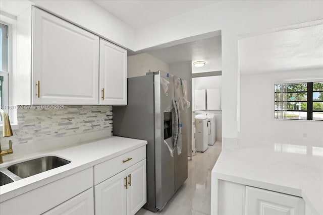 6424 Pierce St, Hollywood, FL 33024 - kitchen with washing machine and clothes dryer, tasteful backsplash, white cabinets, and light countertops