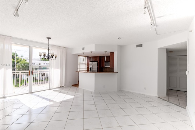 10140 W Bay Harbor Dr Unit 201A, Bay Harbor Islands, FL 33154 - unfurnished living room with rail lighting, a chandelier, a textured ceiling, and light tile patterned flooring