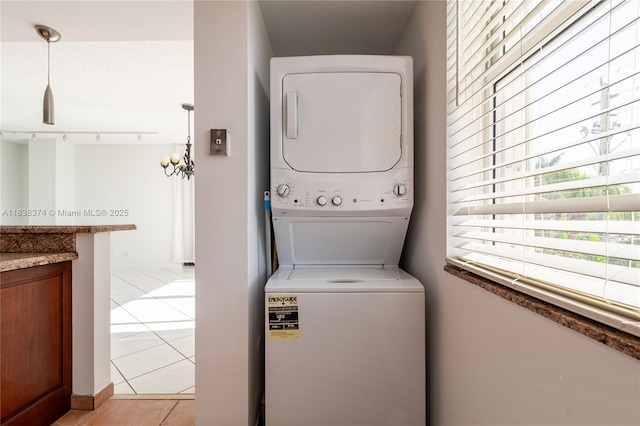 10140 W Bay Harbor Dr Unit 201A, Bay Harbor Islands, FL 33154 - laundry area with estacked washer and dryer, light tile patterned floors, track lighting, and a chandelier